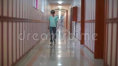 一个男孩正沿着一所教育机构的一条长长的走廊走着。